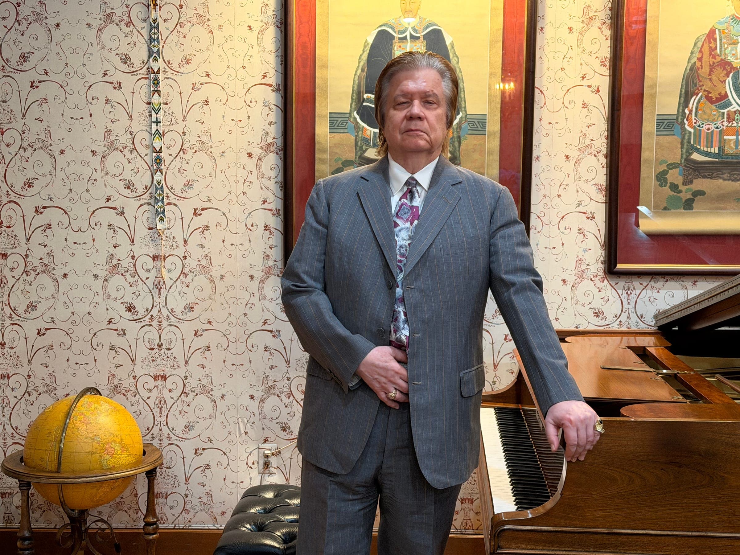Art Greenhaw standing beside a grand piano