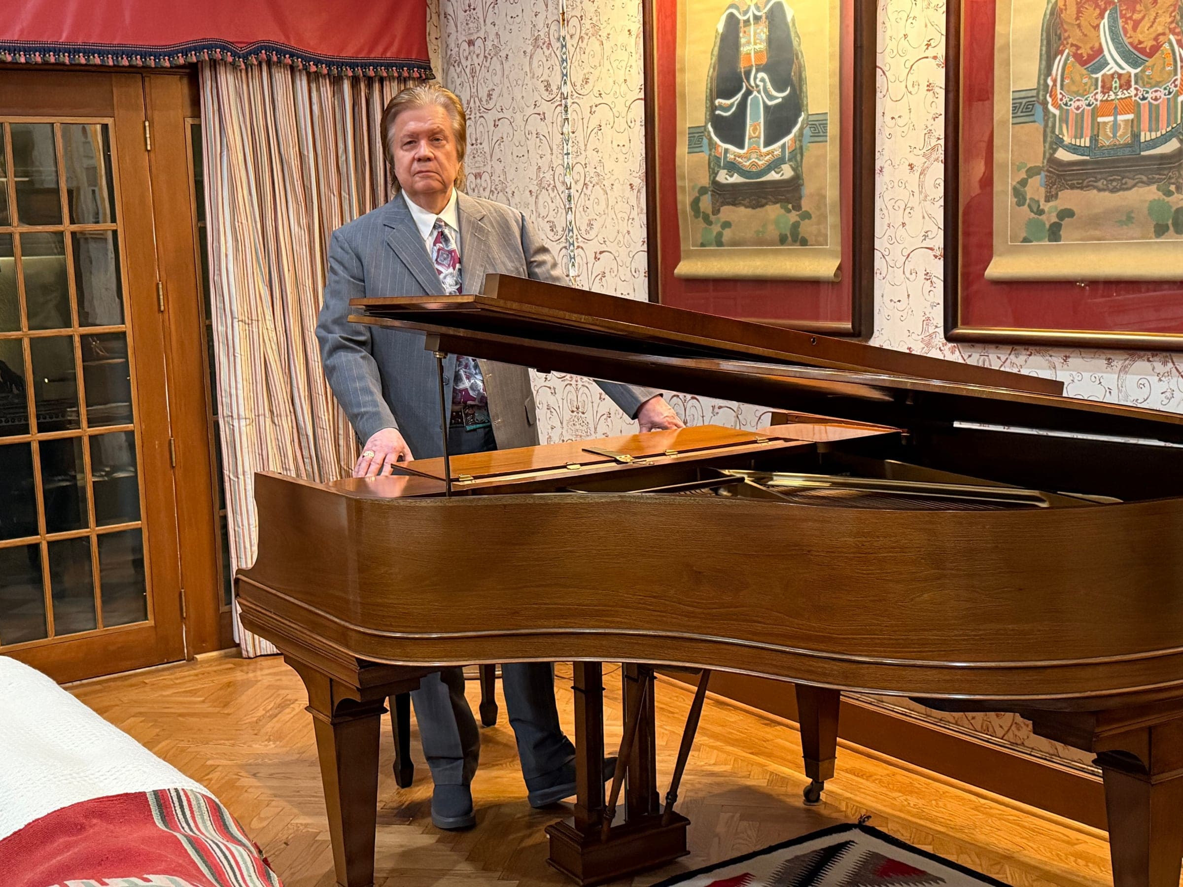 Art Greenhaw standing at the curve of a grand piano