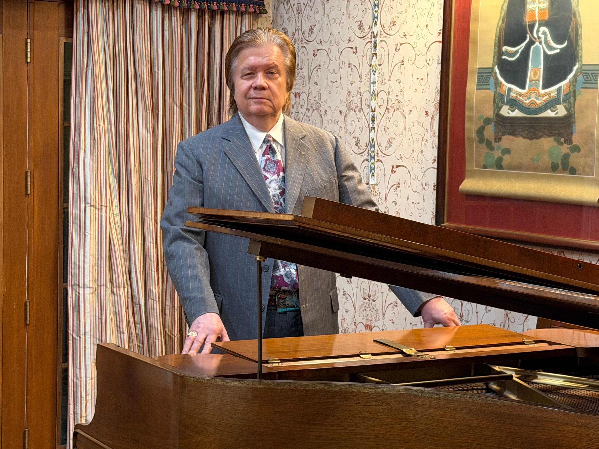 Art Greenhaw resting his hands on a grand piano