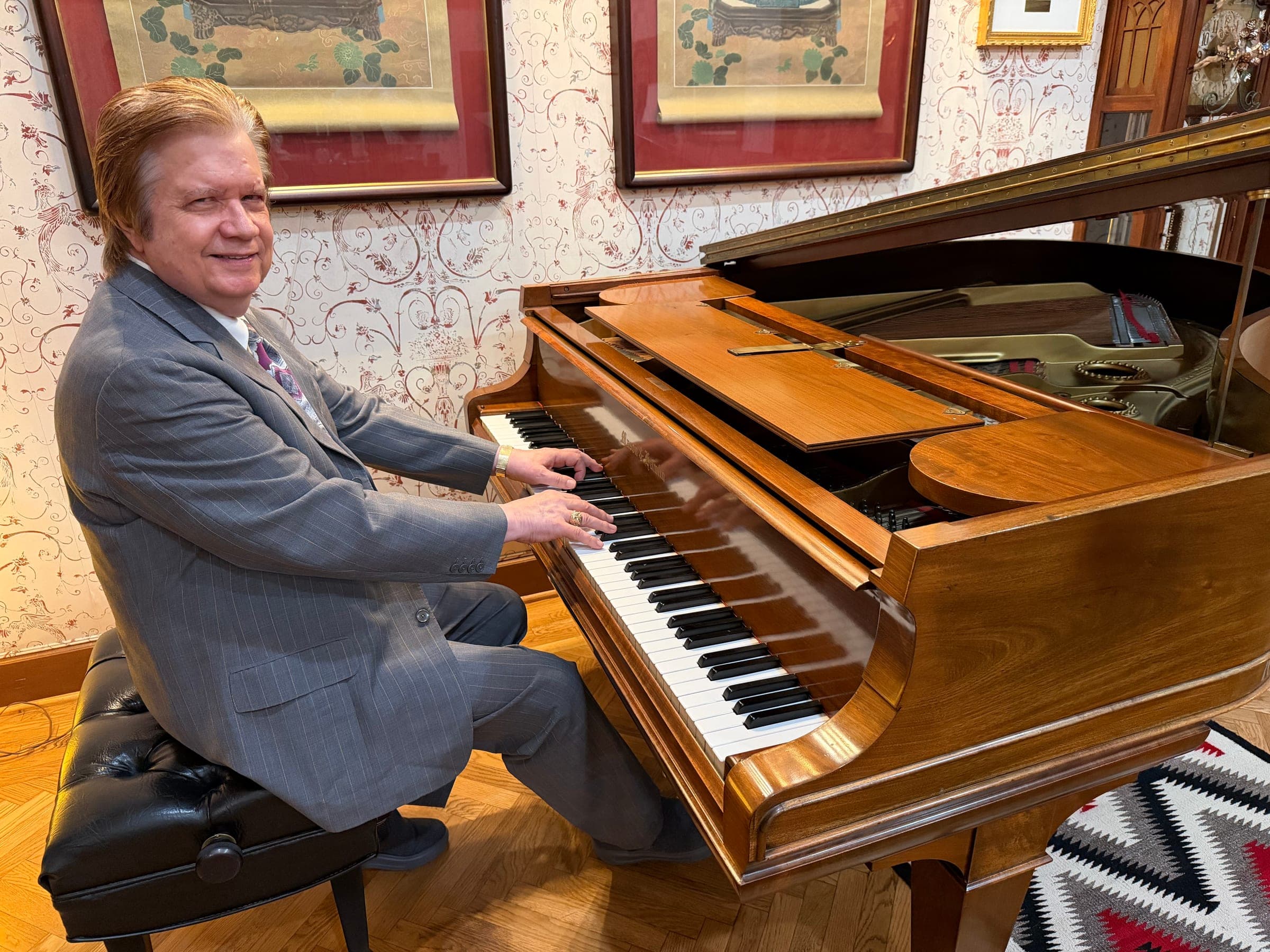 Art Greenhaw smiling at the keyboard of a grand piano
